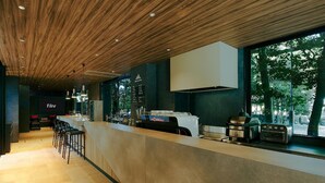 A modern bar area with a wooden ceiling, bar stools, and a counter with a coffee machine and toaster. - Fav Hotel Ise (Ise)