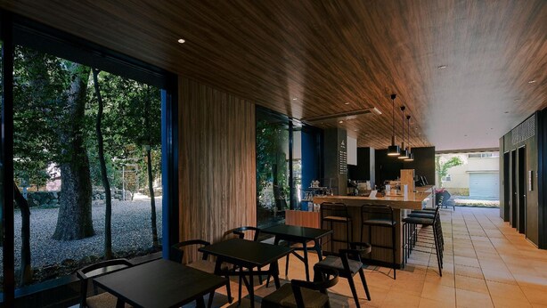 A modern dining area with wooden ceiling and large windows overlooking a garden. - Fav Hotel Ise (Ise)
