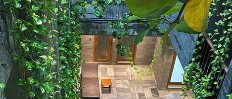 A rectangular pool with clear water, surrounded by stone walls and lush greenery.