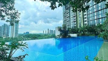 A rooftop infinity pool with a city skyline in the background.