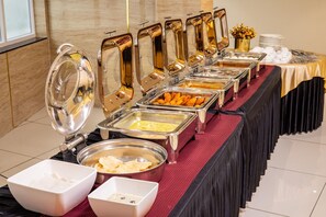 A buffet setup with multiple food dispensers and serving dishes. - Royal Plaza Suites (Mangaluru)