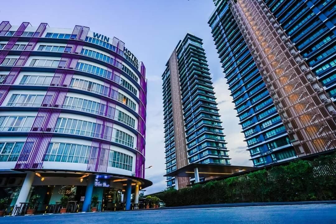 A modern hotel with a curved facade, large windows, and a prominent entrance.