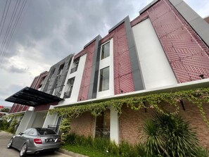 A multi-story residential building with a car parked in front. - Ra Inn Kemang (Jakarta)