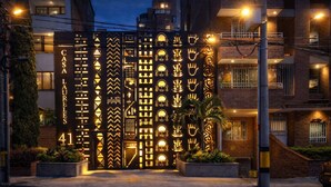 Een gevel met een decoratieve poort, versierd met geometrische patronen en handsymbolen, met het cijfer 41 en de naam "CASA LAURELES".