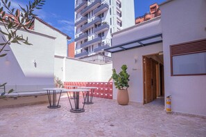 A courtyard with outdoor seating, a potted plant, and a building entrance. - Apt Loft in Laureles, 2 King size beds, AC I Pool (Medellín)