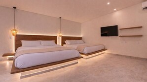 Een moderne slaapkamer met twee bedden, een aan de muur bevestigde televisie en een minimalistisch design.