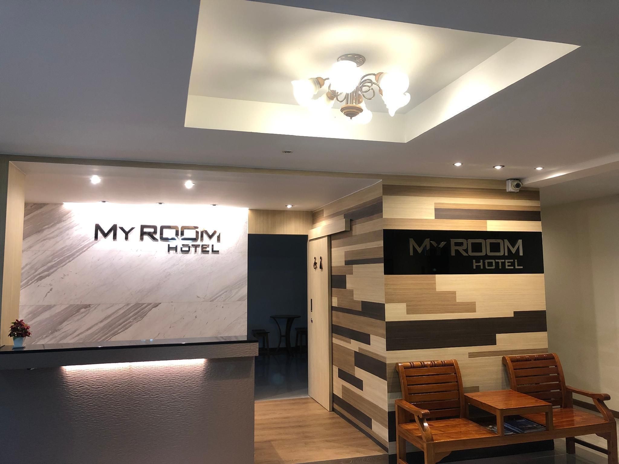 A reception area with a marble counter, a ceiling fan, and wooden chairs.