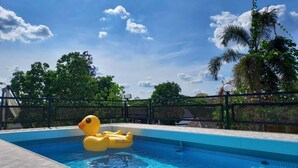 A swimming pool with a yellow inflatable duck, surrounded by a fence and trees. - Maai Horm Boutique Resort (Muak Lek)