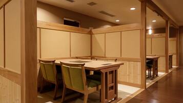 A traditional Japanese-style room with tatami mat flooring, wooden furniture, and sliding doors.