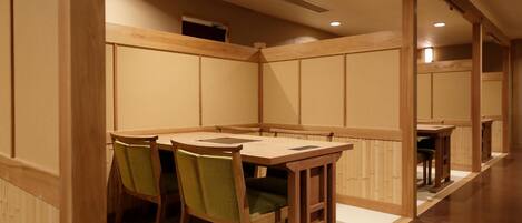 A traditional Japanese-style room with tatami mat flooring, wooden furniture, and sliding doors.