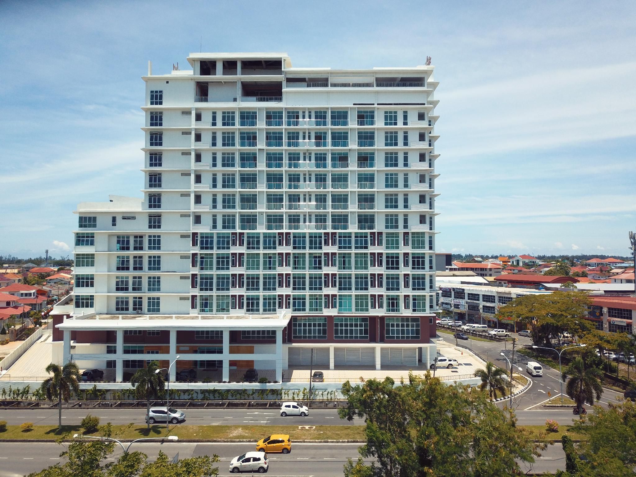 A multi-story hotel with a modern architectural design, featuring a prominent glass facade and a flat roof.