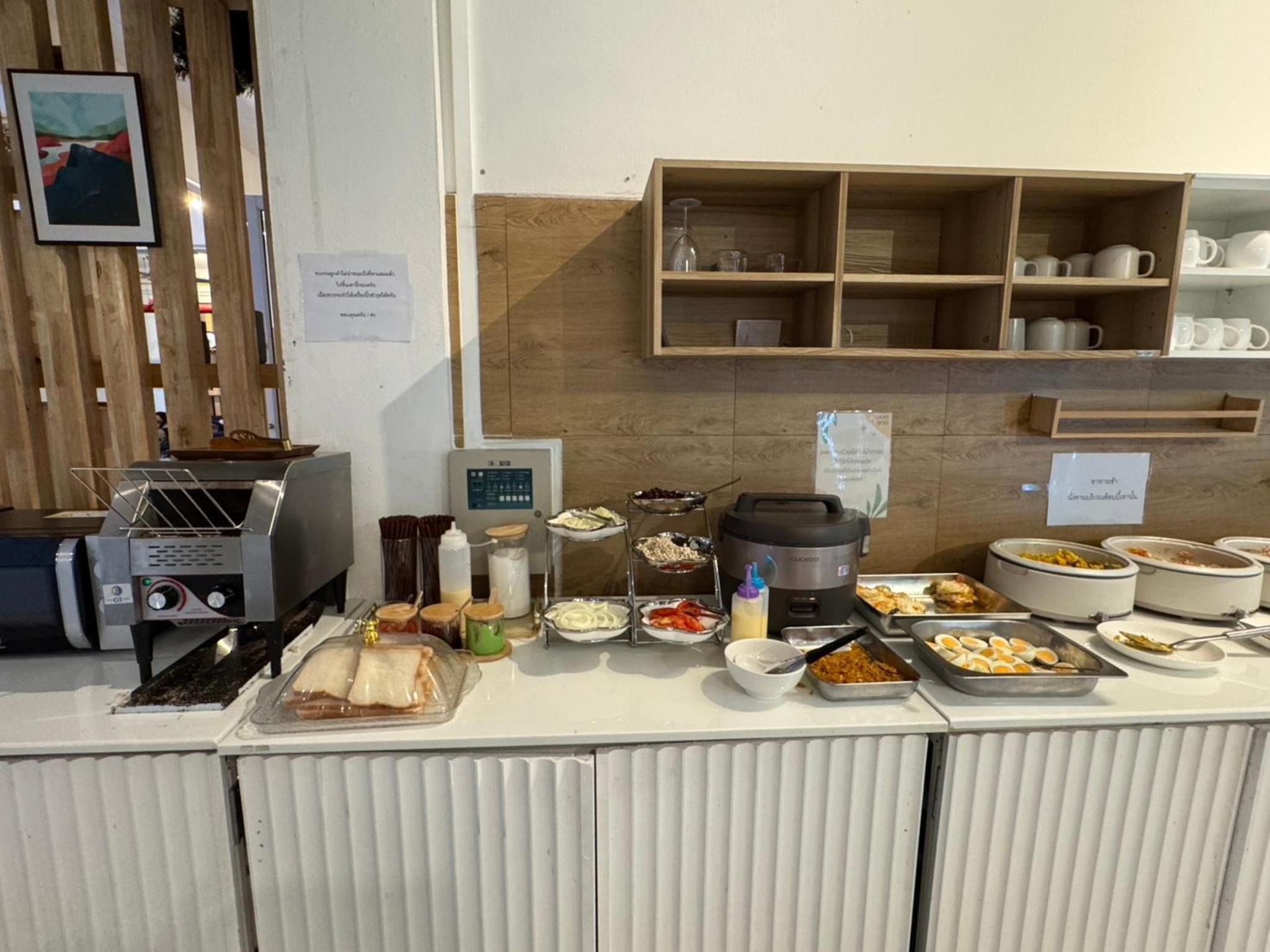 A buffet setup with various food items, a toaster, and a coffee maker.