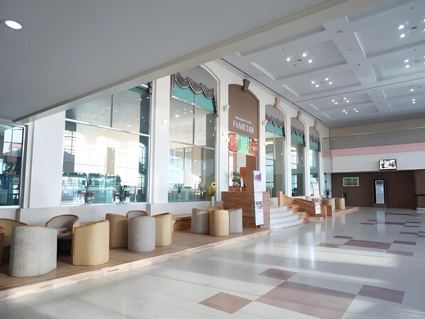A spacious indoor area with large windows, seating arrangements, and a modern architectural design. - Il Sung Seorak Resort (Goseong)