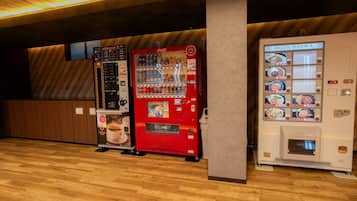 Una hilera de máquinas expendedoras con diversas opciones de bebidas y una máquina de Coca-Cola.