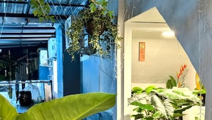 A modern indoor space with a water feature, potted plants, and a staircase leading to another area.