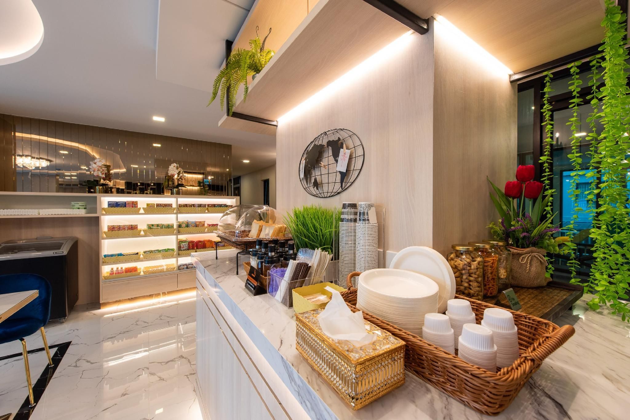 A hotel reception area with a marble floor, a counter with various items, and a wall with a globe decoration.