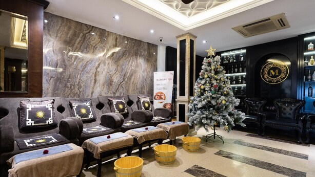 A spa area with massage chairs, a Christmas tree, and a bar with bottles. - Hanoi Memory Premier Hotel Spa (Hanoi)