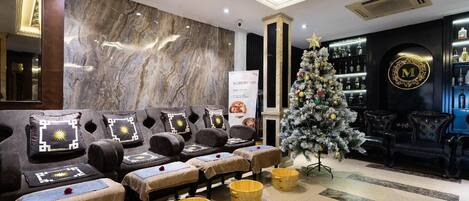 A spa area with massage chairs, a Christmas tree, and a bar with bottles.