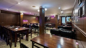 A restaurant with wooden walls, multiple tables, and booths. - Hanoi Memory Premier Hotel Spa (Hanoi)