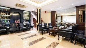A luxurious lobby with leather seating, a bar area with bottles, and a staircase. - Hanoi Memory Premier Hotel Spa (Hanoi)