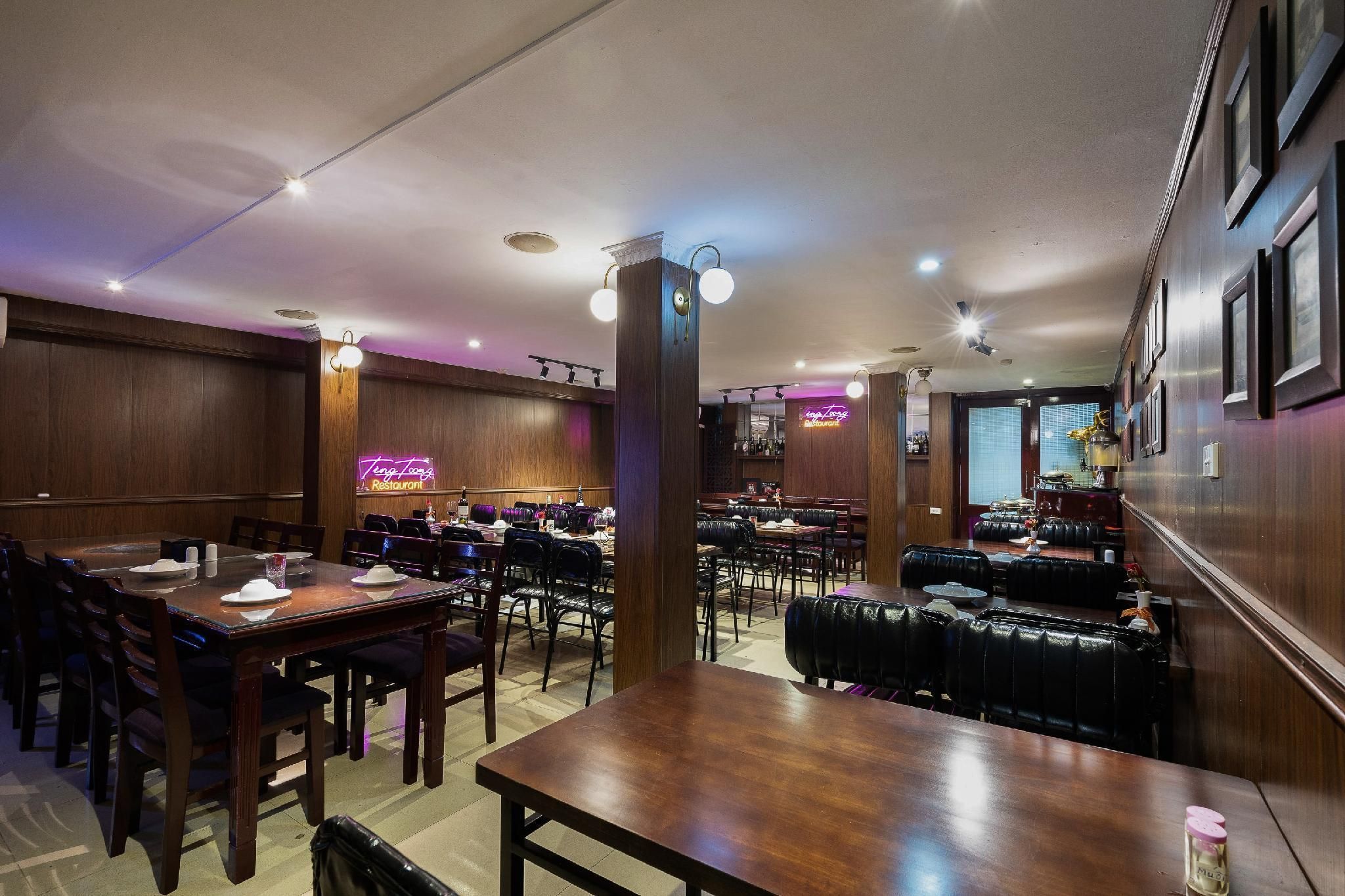 A restaurant with wooden walls, multiple tables, and booths.