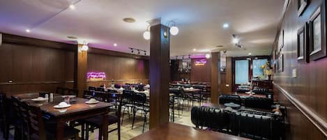 A restaurant with wooden walls, multiple tables, and booths.