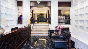 A lobby with a marble floor, a reception desk, a staircase, and a seating area with a vase of flowers. - Hanoi Memory Premier Hotel Spa (Hanoi)