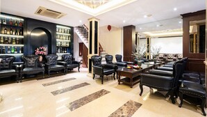 A luxurious lobby with leather seating, a bar area with bottles, and a staircase. - Hanoi Memory Premier Hotel Spa (Hanoi)