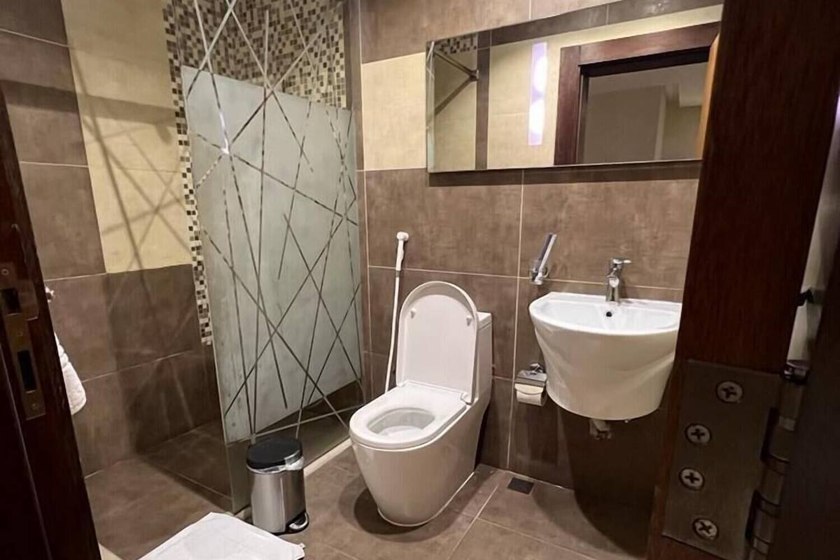 A bathroom with a toilet, sink, and shower area.