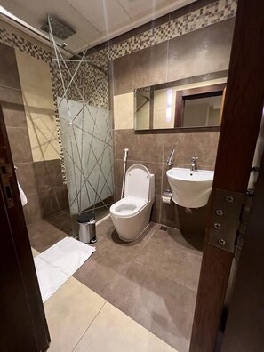 A modern bathroom with a toilet, sink, and shower. - Obhur Home Suites (Jeddah)