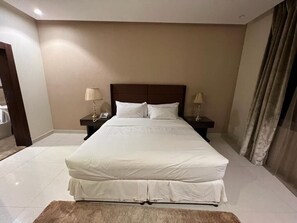 A neatly made bed with white linens in a hotel room. - Obhur Home Suites (Jeddah)