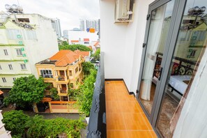 A narrow balcony with a tiled floor, overlooking a courtyard with a building that has a red roof and balconies. - Collection O Havana Airport Hotel (Ho Chi Minh City)