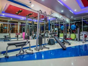 A gym with various exercise equipment, including weight machines, a treadmill, and exercise balls. - Theloft Boutique Nakhonpanom (Nakhon Phanom)