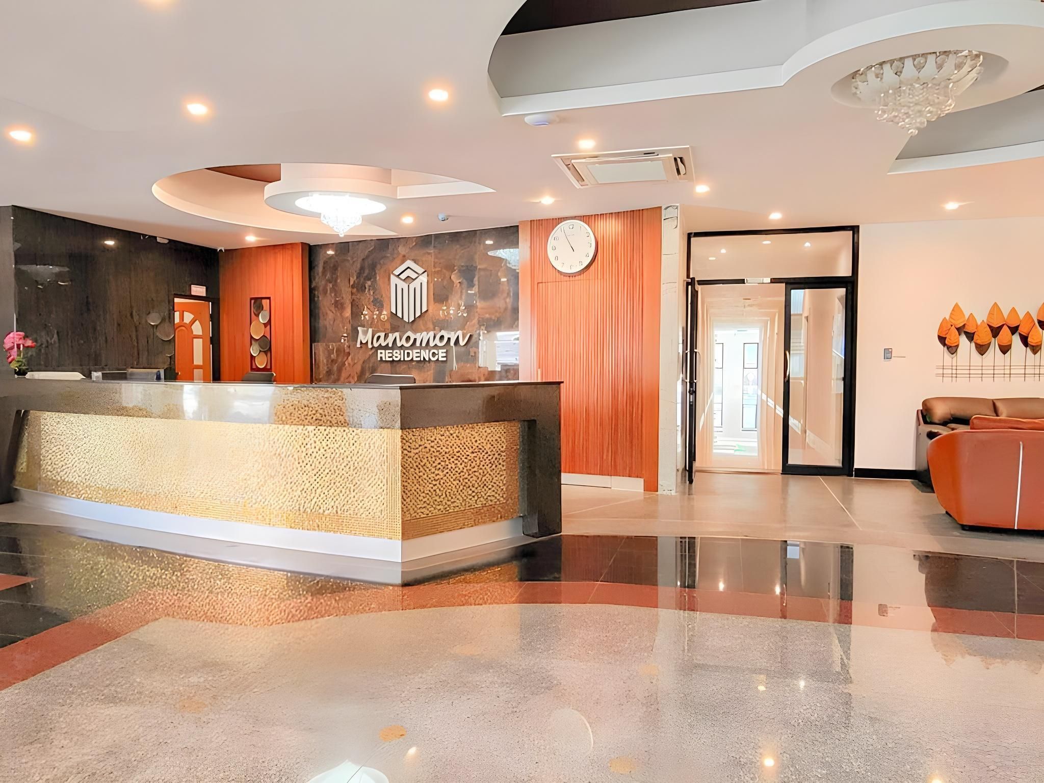 A reception area with a modern design, including a reception desk, a clock, and a chandelier.