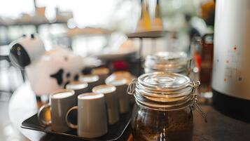Una bandeja con tazas de café y un tarro de café sobre una mesa de madera.