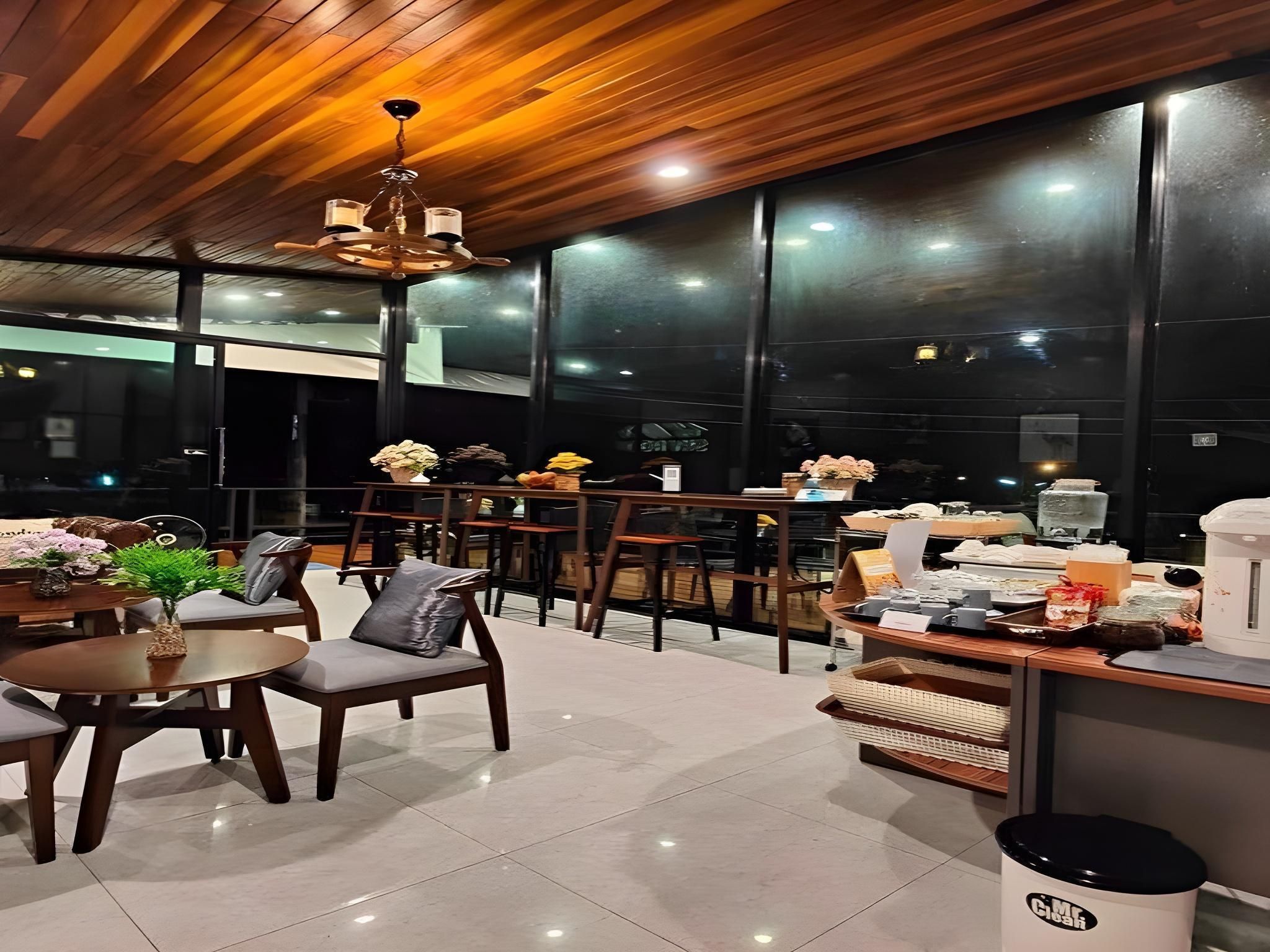 Un restaurante moderno con techo de madera y ventanas amplias, que ofrece vistas del cielo nocturno.
