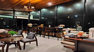 Un restaurante moderno con techo de madera y ventanas amplias, que ofrece vistas del cielo nocturno.