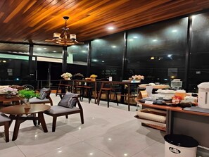 A modern restaurant with wooden ceiling and large windows, offering a view of the night sky. - The Sky Roof Homestay Kiriwong (Lan Saka)