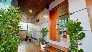 Une terrasse en bois agrémentée de plantes en pot et d’un banc en bois.