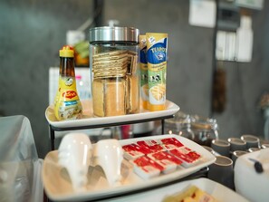 A breakfast buffet with various food items and condiments. - The Sky Roof Homestay Kiriwong (Lan Saka)