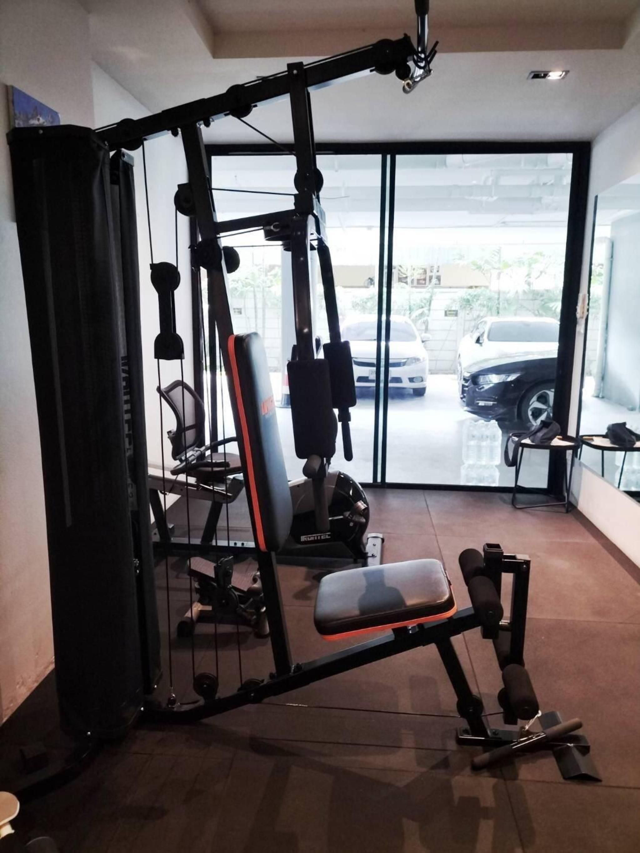 A gym with a squat rack, bench press, and various weight machines.
