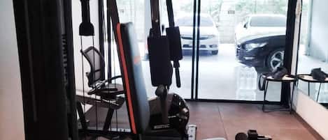 A gym with a squat rack, bench press, and various weight machines.