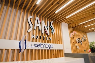 Una recepción con un cartel de Sans Hotels y Luxebridge.