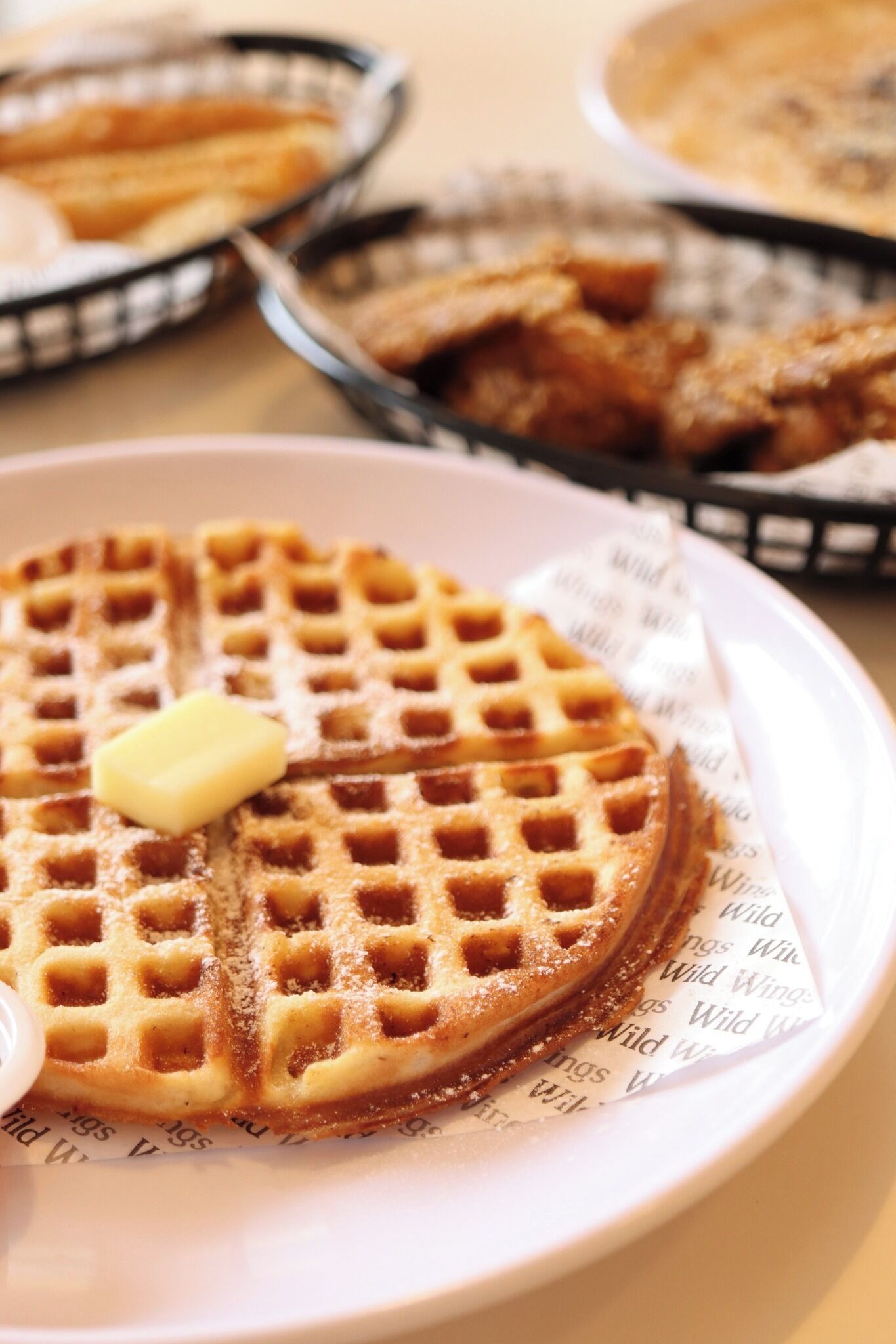 Waffle com manteiga sobre um prato.