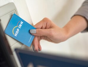 Una mano introduciendo una tarjeta azul en una ranura.