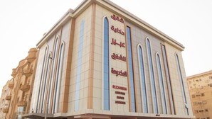 Un bâtiment doté d’une enseigne verticale bien visible, sur laquelle est inscrit un texte en arabe.