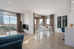 Una sala de estar moderna con comedor, ventanas amplias y vista a la ciudad.