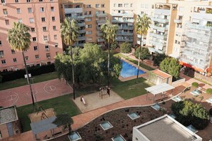 A residential complex with multiple apartment buildings, a swimming pool, and a basketball court. - Enjoybcn Marina Apartment (Barcelona)