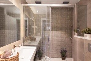 A modern bathroom with a glass-enclosed shower, a large mirror, and a white sink. - Enjoybcn Marina Apartment (Barcelona)
