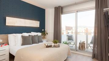 Ein modernes Schlafzimmer mit einem großen Bett, Blick auf die Stadt durch eine Schiebetür und einer blauen Akzentwand.